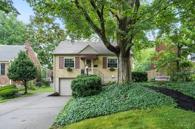 1146 Wilshire Ave, Anderson Twp, OH 45230 - view of front of property with concrete driveway, brick siding, a garage, and a shingled roof