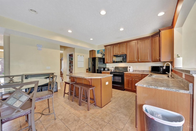 8020 Stoney Ridge Dr, Colerain Twp, OH 45247 - kitchen featuring black appliances, a breakfast bar area, light countertops, a center island, and light tile patterned floors