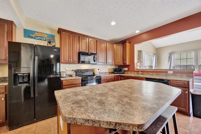 8020 Stoney Ridge Dr, Colerain Twp, OH 45247 - kitchen with black appliances, light tile patterned flooring, a center island, recessed lighting, and a textured ceiling