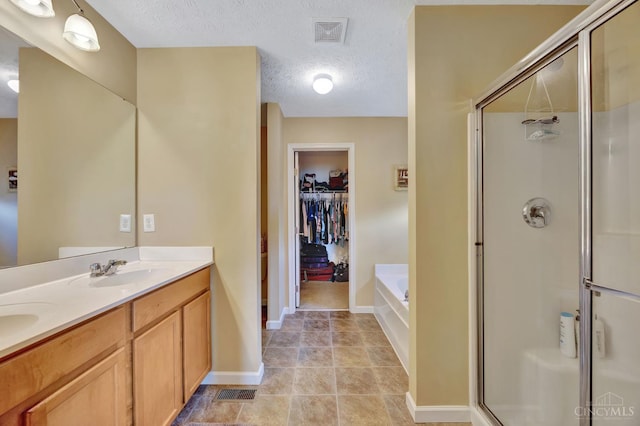 8020 Stoney Ridge Dr, Colerain Twp, OH 45247 - full bath featuring a shower stall, a walk in closet, a bath, double vanity, and a textured ceiling