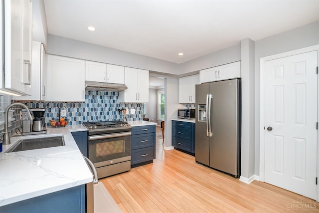 2201 Candlemaker Dr, Anderson Twp, OH 45244 - kitchen with appliances with stainless steel finishes, under cabinet range hood, white cabinets, tasteful backsplash, and blue cabinetry