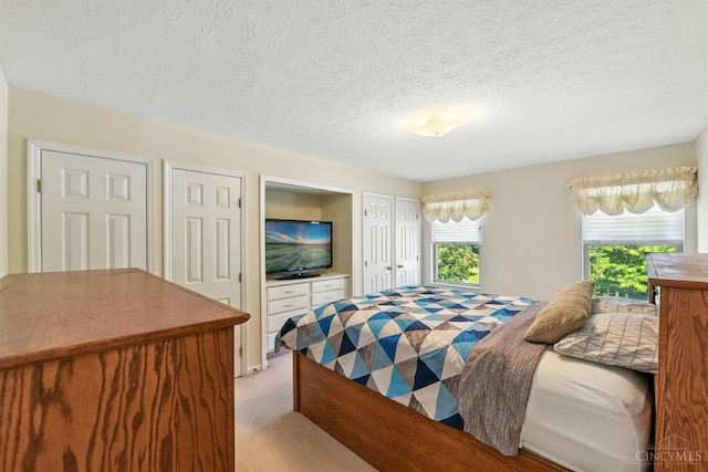 1287 Mcguffey Ln, Union Twp, OH 45103 - bedroom with light carpet, multiple closets, and a textured ceiling