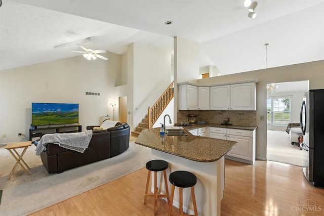 1287 Mcguffey Ln, Union Twp, OH 45103 - kitchen with a peninsula, a breakfast bar, open floor plan, light wood finished floors, and freestanding refrigerator