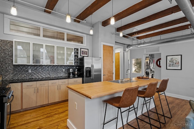 26 E Sixth St Unit 403, Cincinnati, OH 45202 - kitchen featuring appliances with stainless steel finishes, butcher block counters, beamed ceiling, tasteful backsplash, and light wood-style floors