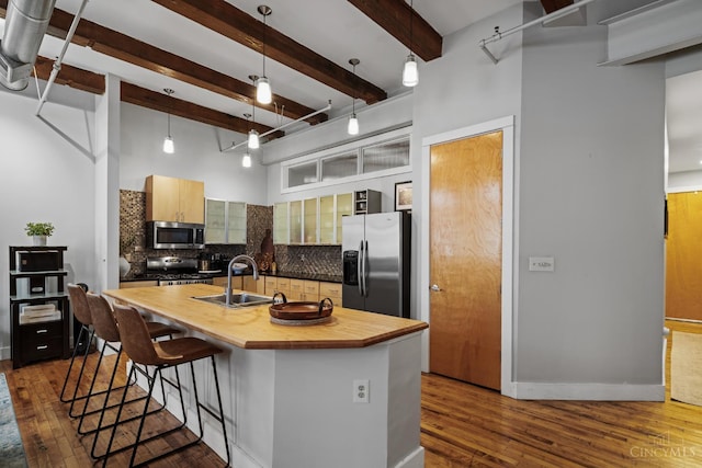 26 E Sixth St Unit 403, Cincinnati, OH 45202 - kitchen featuring stainless steel appliances, butcher block countertops, tasteful backsplash, dark wood-style floors, and a breakfast bar area