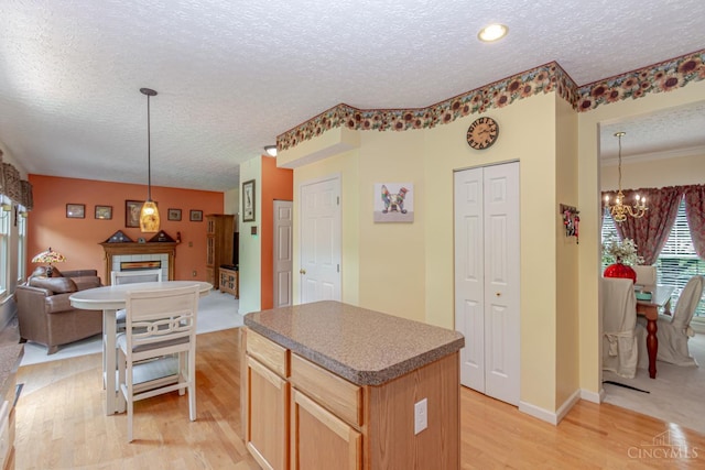 2220 Sulky Ct, Beavercreek Twp, OH 45434 - kitchen with a textured ceiling, a chandelier, open floor plan, light wood-style floors, and a kitchen island