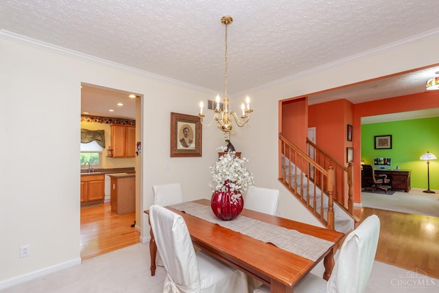 2220 Sulky Ct, Beavercreek Twp, OH 45434 - dining area with a chandelier, a textured ceiling, ornamental molding, stairway, and light wood-type flooring