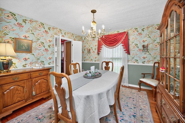5613 Williamsburg Way, Fairfield, OH 45014 - dining area with wallpapered walls, a wainscoted wall, a chandelier, a textured ceiling, and wood finished floors