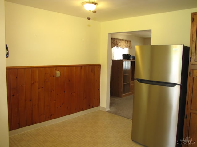 2573 Adams Rd, Colerain Twp, OH 45231 - kitchen featuring freestanding refrigerator, wainscoting, light flooring, and wood walls