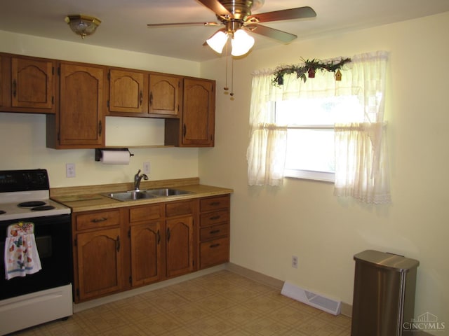 2573 Adams Rd, Colerain Twp, OH 45231 - kitchen with white range with electric cooktop, brown cabinetry, ceiling fan, light flooring, and light countertops