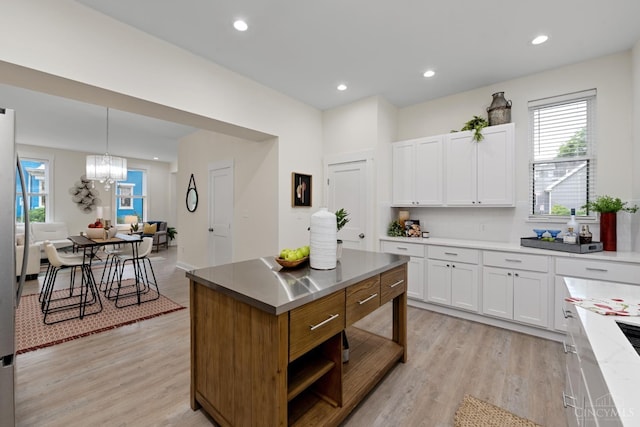 4249 Chambers St, Cincinnati, OH 45223 - kitchen featuring white cabinets, light wood finished floors, a chandelier, healthy amount of natural light, and recessed lighting