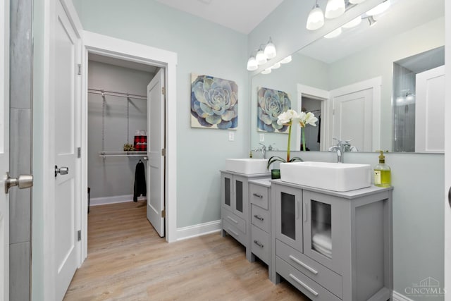 4249 Chambers St, Cincinnati, OH 45223 - bathroom featuring double vanity, wood finished floors, and a walk in closet