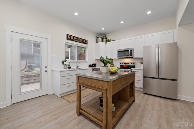 4249 Chambers St, Cincinnati, OH 45223 - kitchen with stainless steel appliances, white cabinets, light wood finished floors, decorative backsplash, and recessed lighting
