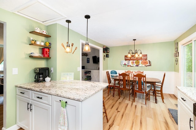 8558 High Trail Ct, Deerfield Twp, OH 45040 - kitchen with light wood-style floors, white cabinetry, wainscoting, hanging light fixtures, and a peninsula
