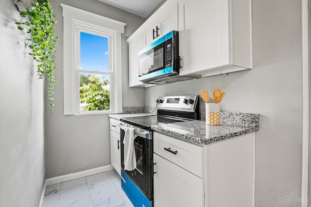 3997 Washington Ave, Cheviot, OH 45211 - kitchen with appliances with stainless steel finishes, light marble finish floors, light stone countertops, and white cabinetry