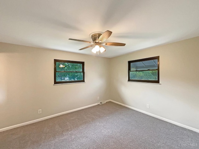 3198 Sunnyhollow Ln, Green Twp, OH 45239 - empty room with healthy amount of natural light, ceiling fan, and dark colored carpet