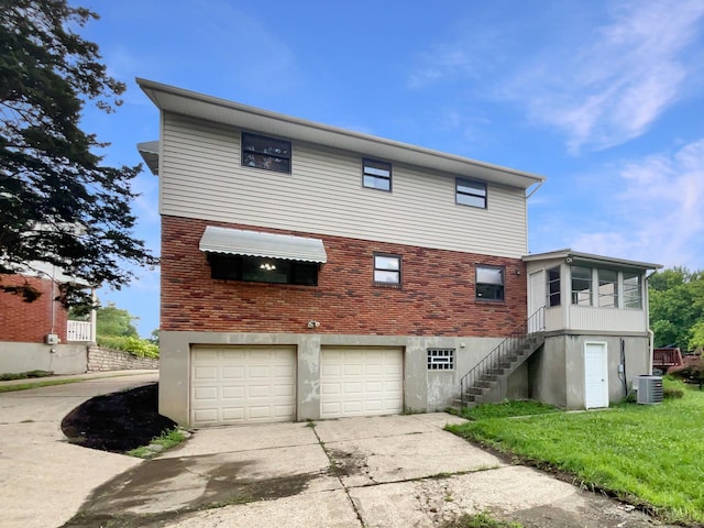 3198 Sunnyhollow Ln, Green Twp, OH 45239 - rear view of property featuring an attached garage, driveway, brick siding, and stairway