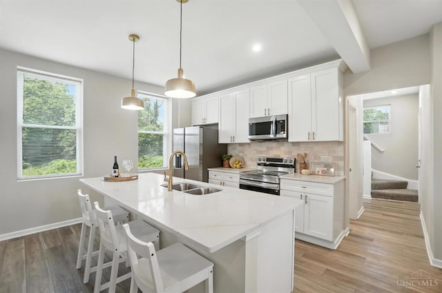 1582 Dixmont Ave, Cincinnati, OH 45207 - kitchen featuring appliances with stainless steel finishes, decorative backsplash, plenty of natural light, light wood-type flooring, and beam ceiling
