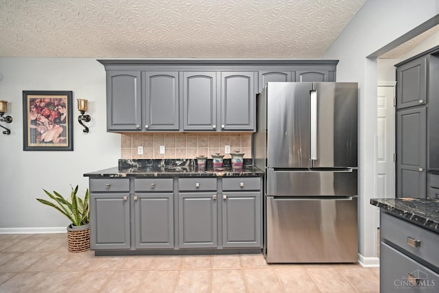 4154 Fieldsedge Dr, Mason, OH 45040 - kitchen featuring freestanding refrigerator, gray cabinets, dark stone countertops, and decorative backsplash