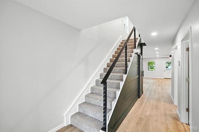 152 N College St, Sabina, OH 45169 - stairs with wood finished floors, a barn door, and recessed lighting