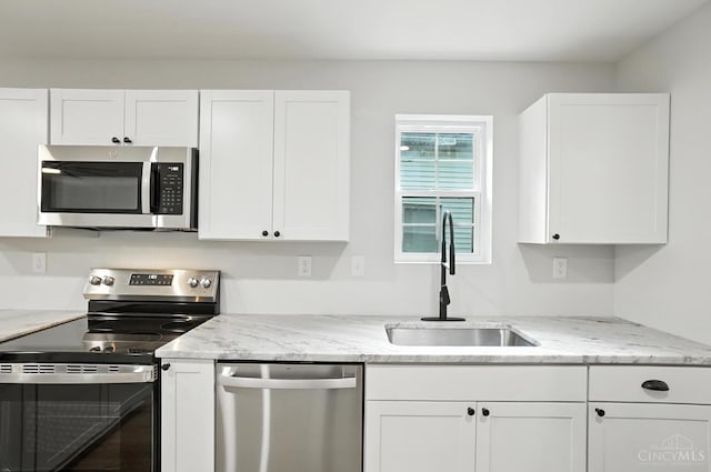 152 N College St, Sabina, OH 45169 - kitchen featuring appliances with stainless steel finishes, white cabinetry, and light stone countertops