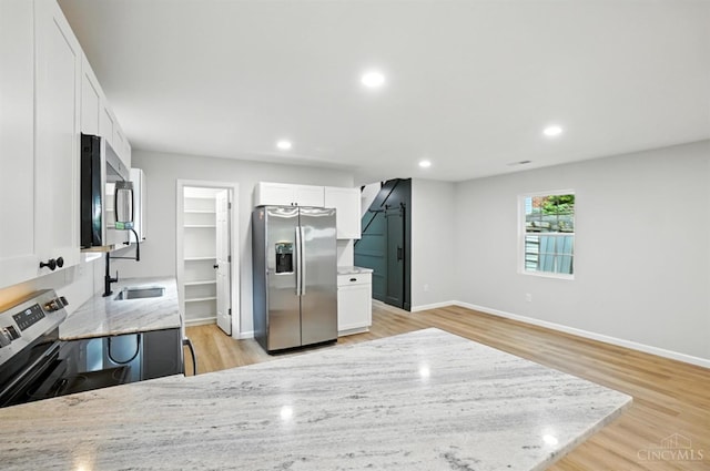 152 N College St, Sabina, OH 45169 - kitchen with appliances with stainless steel finishes, light stone countertops, light wood-style floors, white cabinetry, and recessed lighting