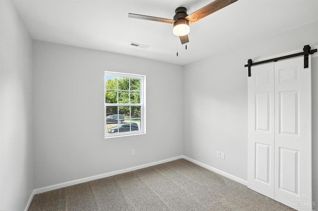 152 N College St, Sabina, OH 45169 - spare room featuring ceiling fan, a barn door, and carpet flooring