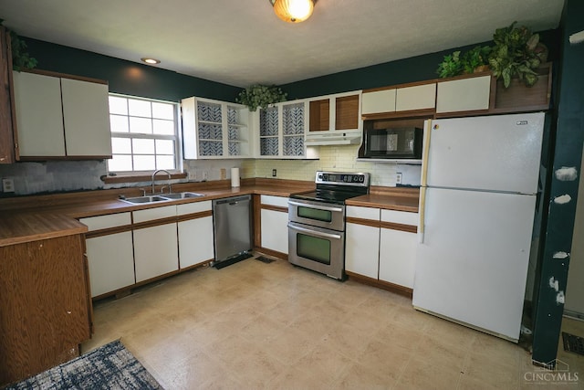 881 Trails End Dr, Liberty Twp, OH 45050 - kitchen with stainless steel appliances, under cabinet range hood, white cabinetry, tasteful backsplash, and wood counters