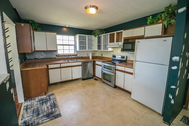 881 Trails End Dr, Liberty Twp, OH 45050 - kitchen with stainless steel appliances, white cabinetry, under cabinet range hood, and tasteful backsplash
