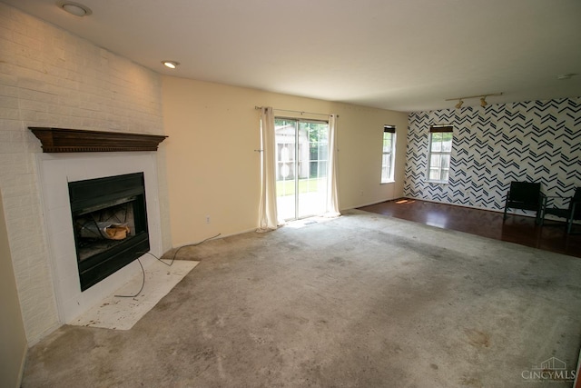 881 Trails End Dr, Liberty Twp, OH 45050 - unfurnished living room with carpet floors, a fireplace, plenty of natural light, and an accent wall