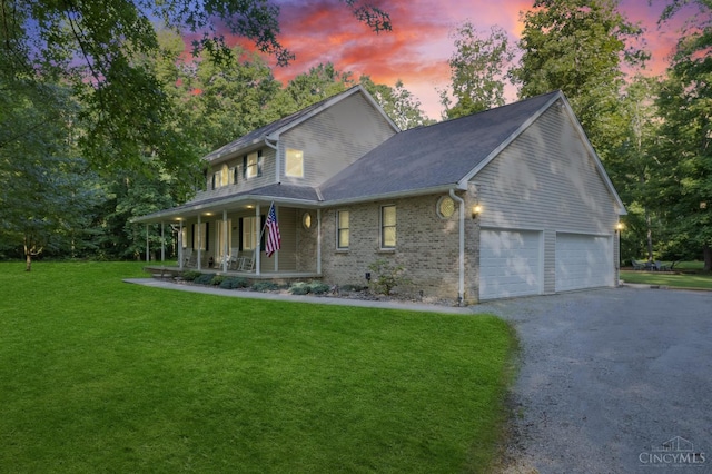 3067 Sugartree Rd, Tate Twp, OH 45106 - view of front of home with covered porch, driveway, a garage, a front yard, and brick siding
