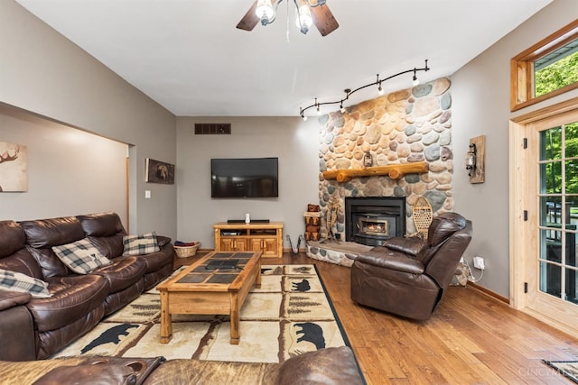 3067 Sugartree Rd, Tate Twp, OH 45106 - living area featuring rail lighting, wood finished floors, ceiling fan, and a stone fireplace