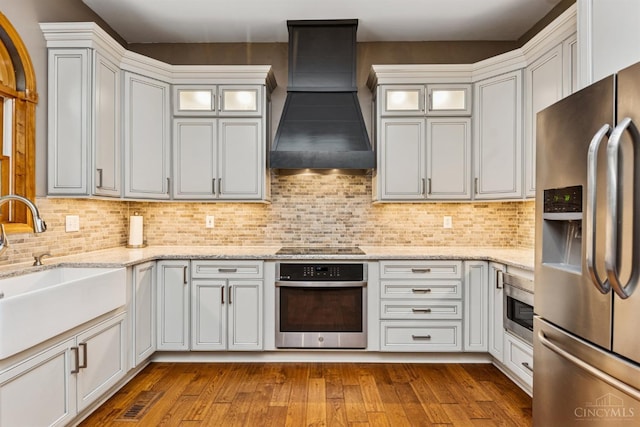 3067 Sugartree Rd, Tate Twp, OH 45106 - kitchen with appliances with stainless steel finishes, custom exhaust hood, dark wood-style floors, and decorative backsplash