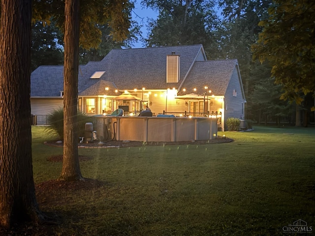 3067 Sugartree Rd, Tate Twp, OH 45106 - rear view of property with a lawn, a covered pool, and a chimney