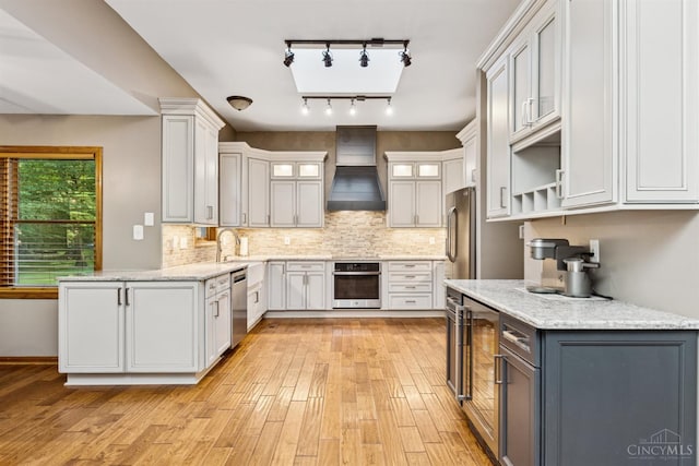 3067 Sugartree Rd, Tate Twp, OH 45106 - kitchen featuring stainless steel appliances, premium range hood, light wood-type flooring, and decorative backsplash