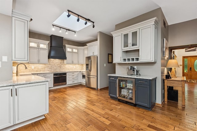 3067 Sugartree Rd, Tate Twp, OH 45106 - kitchen with premium range hood, stainless steel appliances, wine cooler, backsplash, and light stone countertops