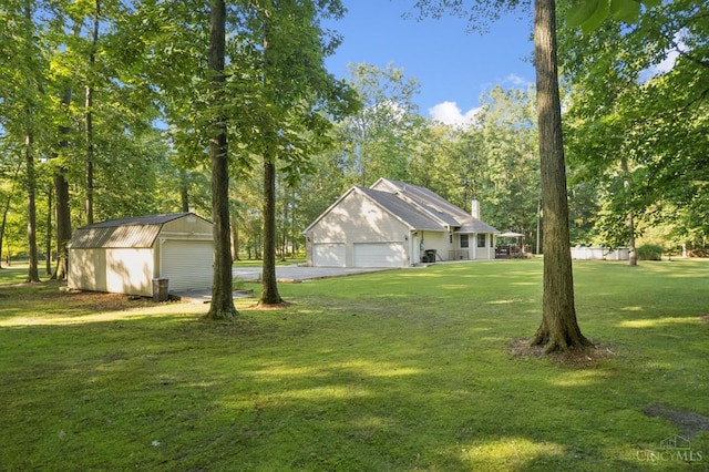 3067 Sugartree Rd, Tate Twp, OH 45106 - view of green lawn featuring a garage, view of wooded area, and an outbuilding