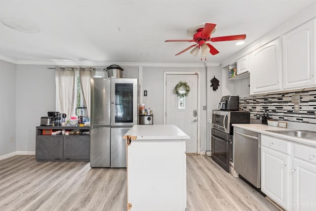 3252 Struble, Colerain Twp, OH 45251 - kitchen featuring stainless steel appliances, light wood finished floors, ceiling fan, a kitchen island, and backsplash
