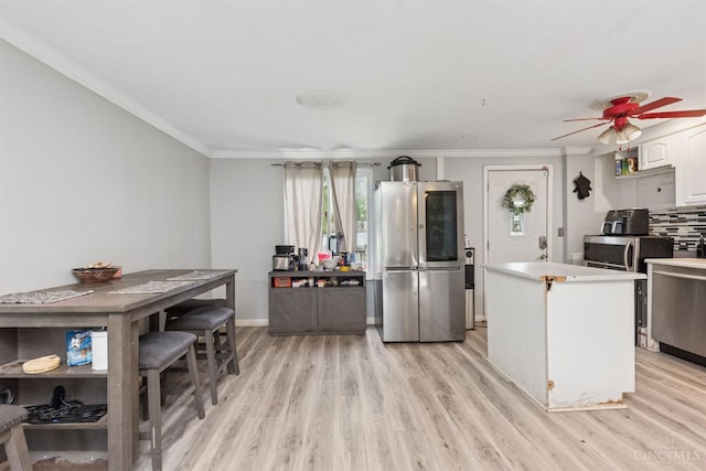 3252 Struble, Colerain Twp, OH 45251 - kitchen featuring appliances with stainless steel finishes, light wood finished floors, crown molding, white cabinets, and ceiling fan