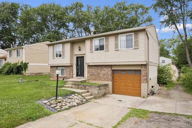 3252 Struble, Colerain Twp, OH 45251 - raised ranch featuring concrete driveway, a front yard, brick siding, and a garage