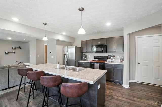 2821 Pine Leaf Ct, Hamilton, OH 45013 - kitchen featuring black appliances, light countertops, dark wood-style floors, a textured ceiling, and a kitchen bar