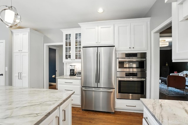 7070 Ravens Run, Anderson Twp, OH 45244 - kitchen with stainless steel appliances, glass insert cabinets, white cabinetry, dark wood-style flooring, and light stone counters