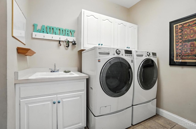 7070 Ravens Run, Anderson Twp, OH 45244 - laundry room featuring washing machine and clothes dryer, cabinet space, and light tile patterned floors