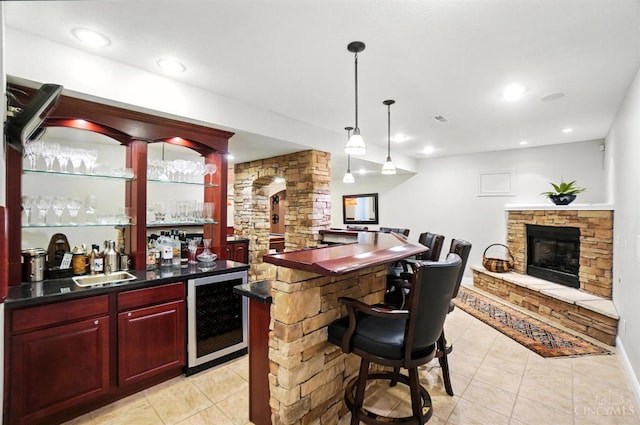 7070 Ravens Run, Anderson Twp, OH 45244 - indoor wet bar featuring beverage cooler, light tile patterned flooring, a stone fireplace, decorative light fixtures, and recessed lighting