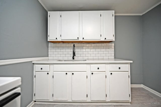 26 Boltin St, Dayton, OH 45403 - kitchen with light countertops, decorative backsplash, white cabinetry, and crown molding