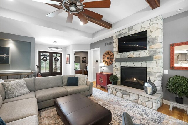 7574 Copper Creek Ln, Colerain Twp, OH 45247 - living room with a ceiling fan, wood finished floors, beamed ceiling, and a stone fireplace