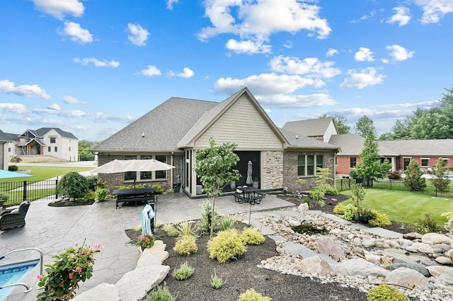 7574 Copper Creek Ln, Colerain Twp, OH 45247 - rear view of house with a patio, a fenced backyard, and stone siding