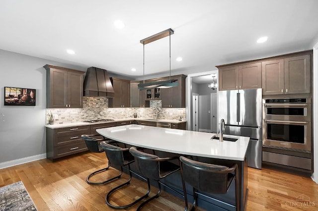 7574 Copper Creek Ln, Colerain Twp, OH 45247 - kitchen featuring appliances with stainless steel finishes, custom range hood, light countertops, dark brown cabinetry, and recessed lighting