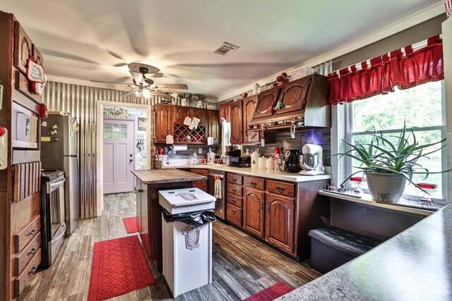 1851 Parker Rd, Goshen Twp, OH 45150 - kitchen with stainless steel electric range oven, a ceiling fan, a center island, wood finished floors, and decorative backsplash