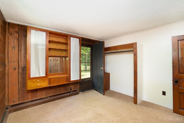 2765 Tater Ridge Rd, West Union, OH 45693 - unfurnished bedroom with baseboard heating, carpet flooring, wooden walls, a closet, and crown molding